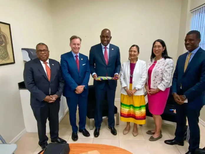 PM Roosevelt Skerrit while receiving Diplomatic Feather from US Ambassador Roger Nyhus